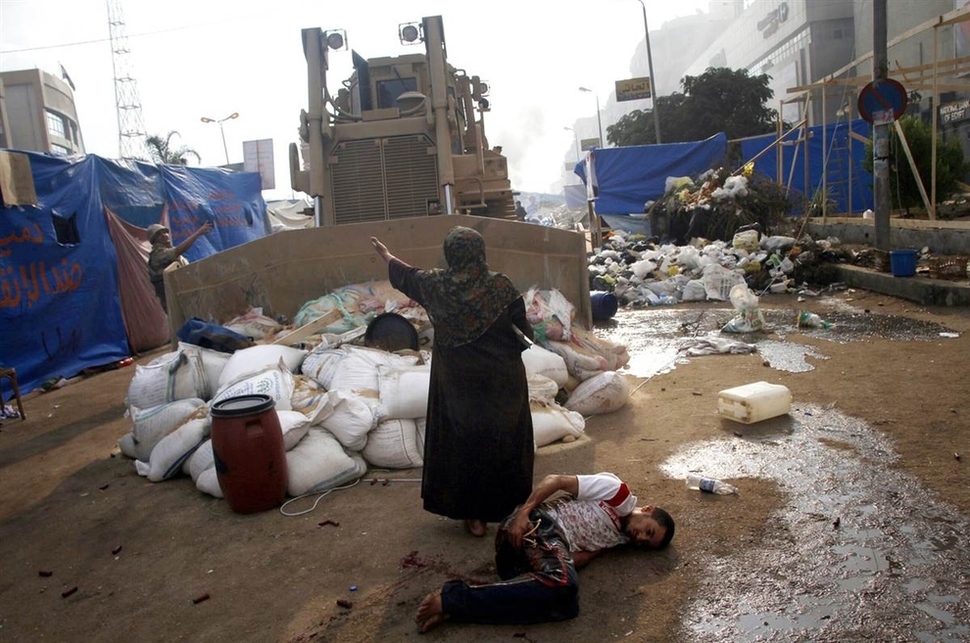14. Women defends a protester from a bulldozer in Egypt