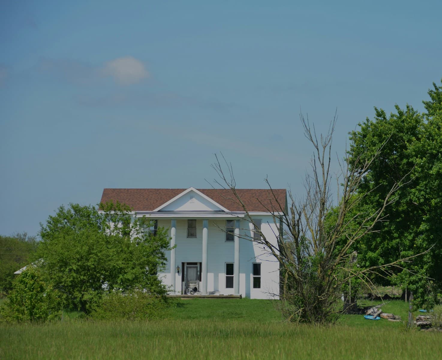 a white house in the middle of a field