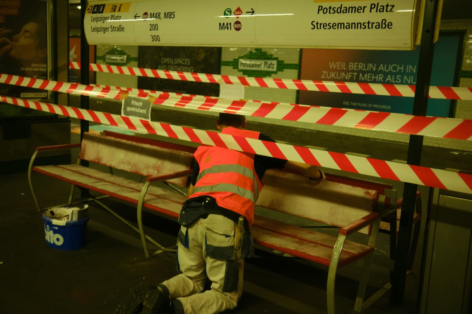 a man in an orange safety vest working on a bench