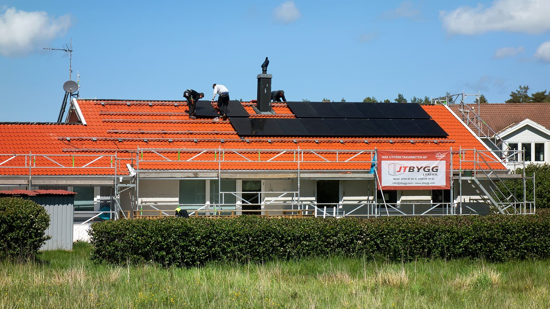Workers installing rooftop solar panels on a residential home