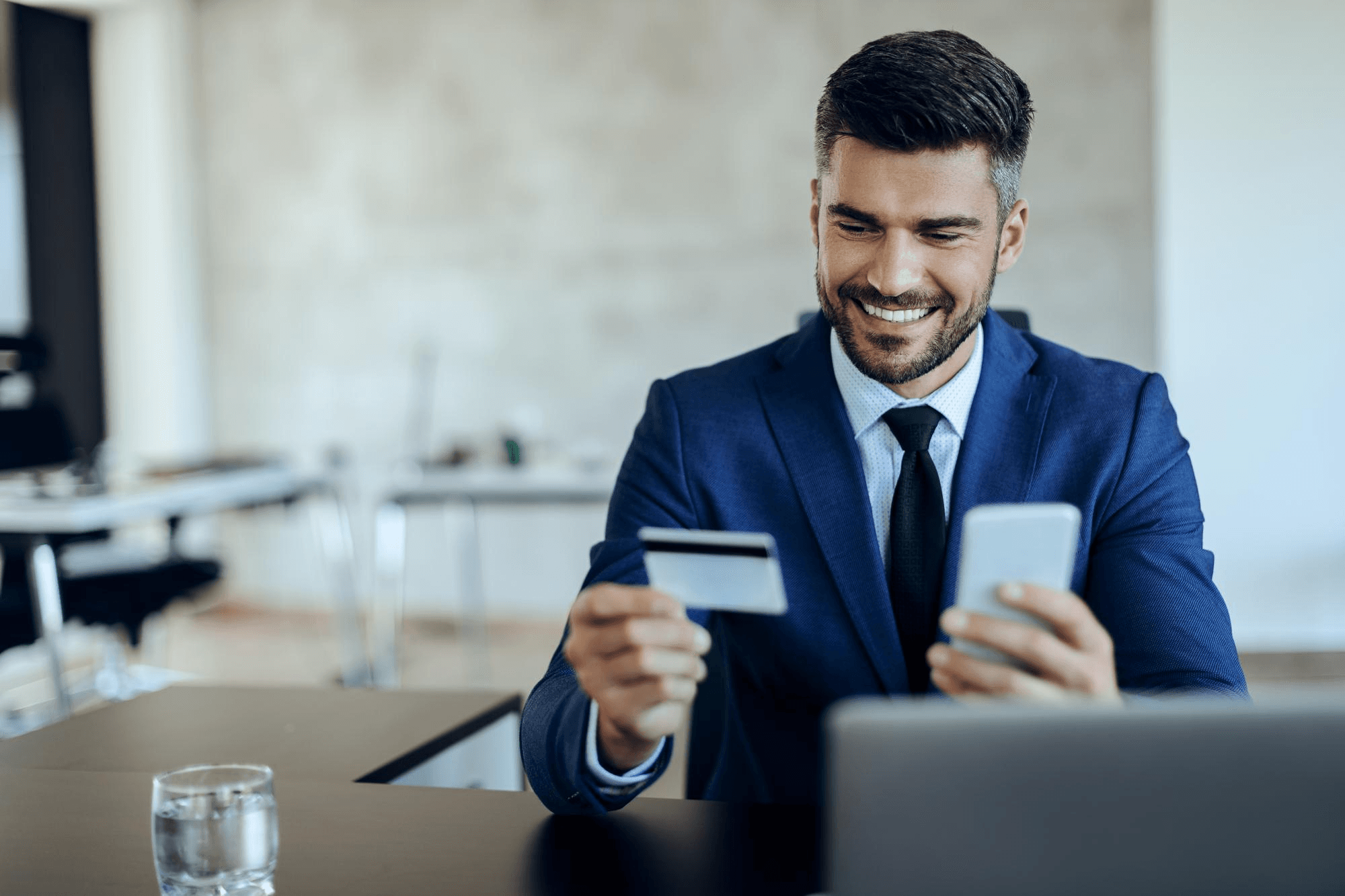 Businessman doing online banking with credit card and phone