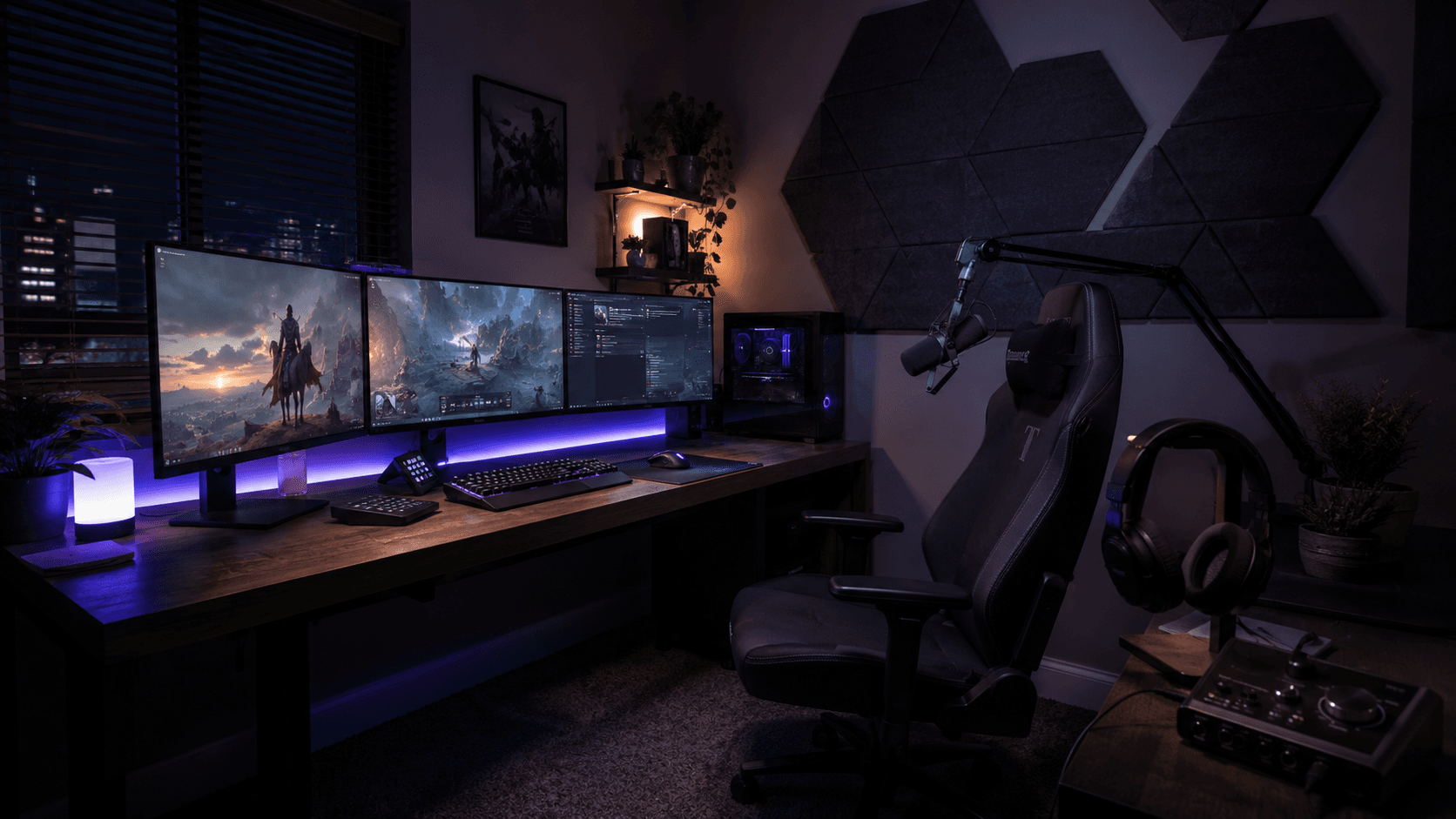 A gaming streaming desk with triple monitors, a boom-arm microphone, and acoustic panels on the wall