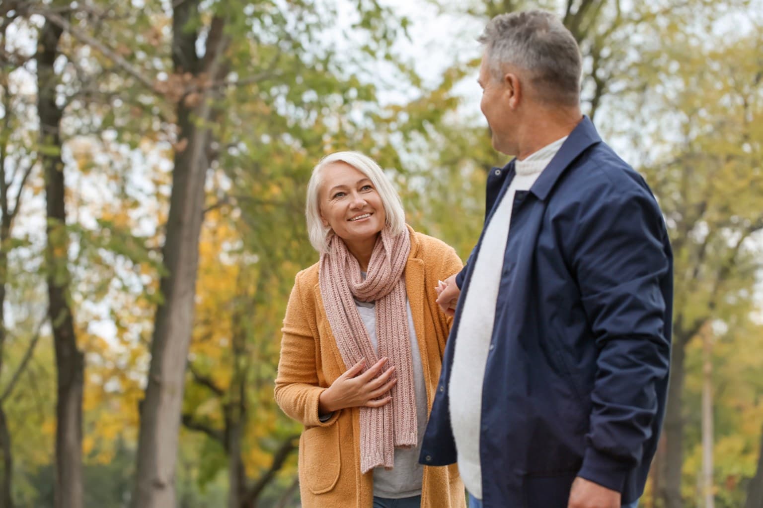 Couple walking together through a park on a cool autumn day