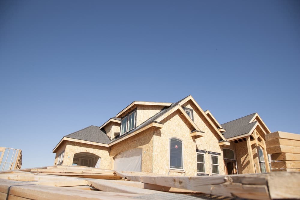 New house under construction with framed walls and stacked lumber