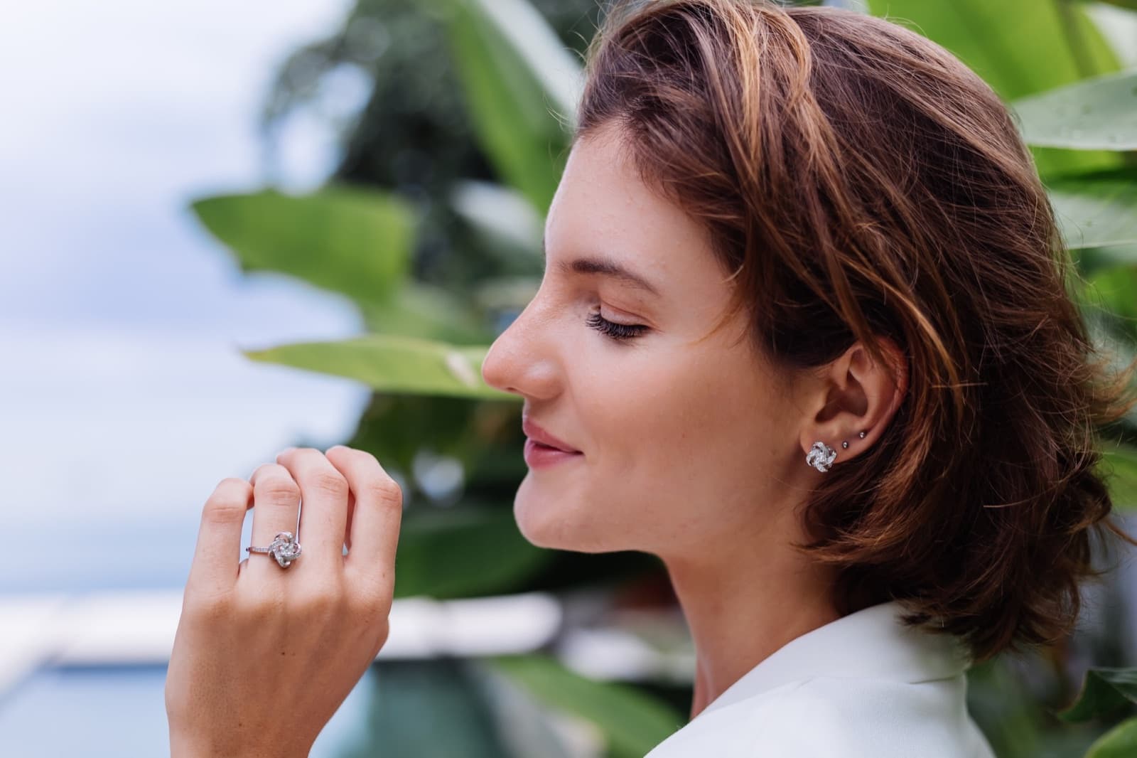 Woman wearing jewellery and a white blazer, illustrating marquise diamond engagement ring style