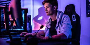 a man sitting in front of a computer monitor