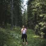 woman carrying backpack on forest