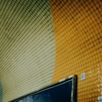 A colorful mosaic tunnel wall is shown.