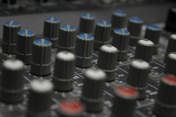 a close up of a sound board with many knobs