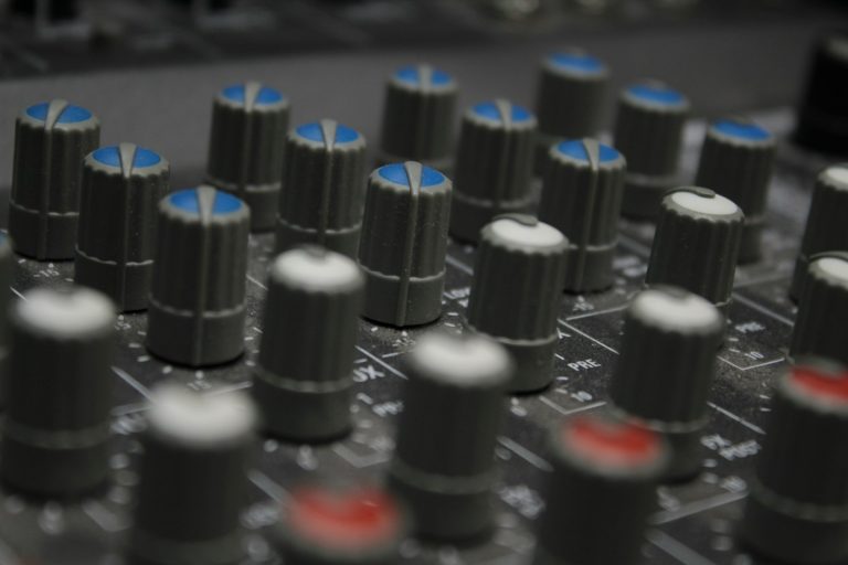 a close up of a sound board with many knobs