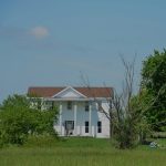 a white house in the middle of a field