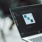 A laptop displays data analysis on its screen.