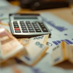 A calculator sitting on top of a pile of money