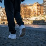 person in black pants and gray nike sneakers