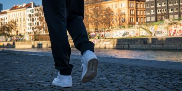 person in black pants and gray nike sneakers