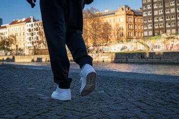 person in black pants and gray nike sneakers