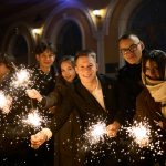 Group of friends celebrating with sparklers at night