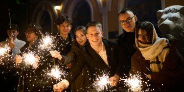 Group of friends celebrating with sparklers at night