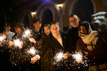 Group of friends celebrating with sparklers at night