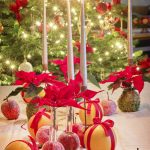 a table topped with apples and candles next to a christmas tree