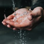 clear liquid pouring on person's hands