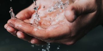 clear liquid pouring on person's hands
