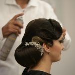 a woman getting her hair done by a hair stylist