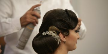 a woman getting her hair done by a hair stylist