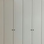 a room with a bunch of white cupboards