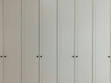 a room with a bunch of white cupboards