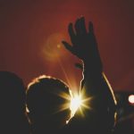 silhouette of man raising his hands inside deemed room