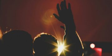 silhouette of man raising his hands inside deemed room
