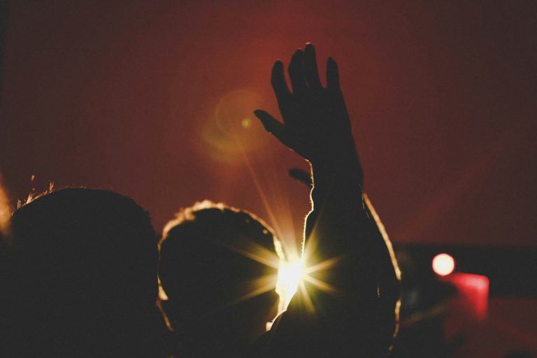 silhouette of man raising his hands inside deemed room