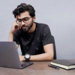a man sitting in front of a laptop computer