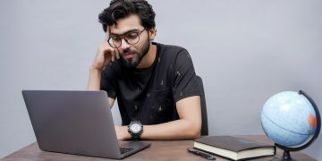 a man sitting in front of a laptop computer
