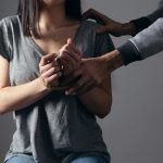 woman in gray scoop neck shirt holding her hands