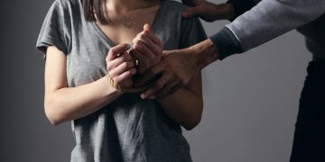 woman in gray scoop neck shirt holding her hands