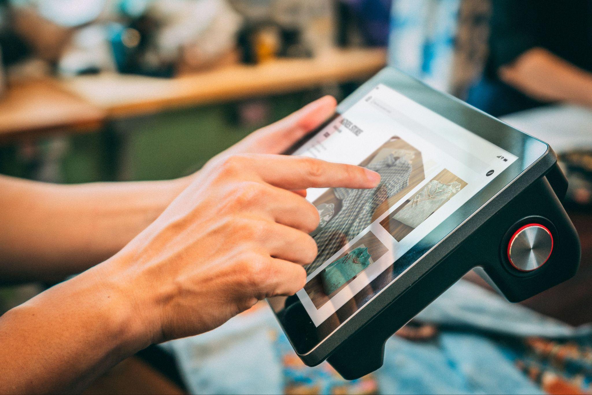 A person browsing and shopping on a tablet touchscreen