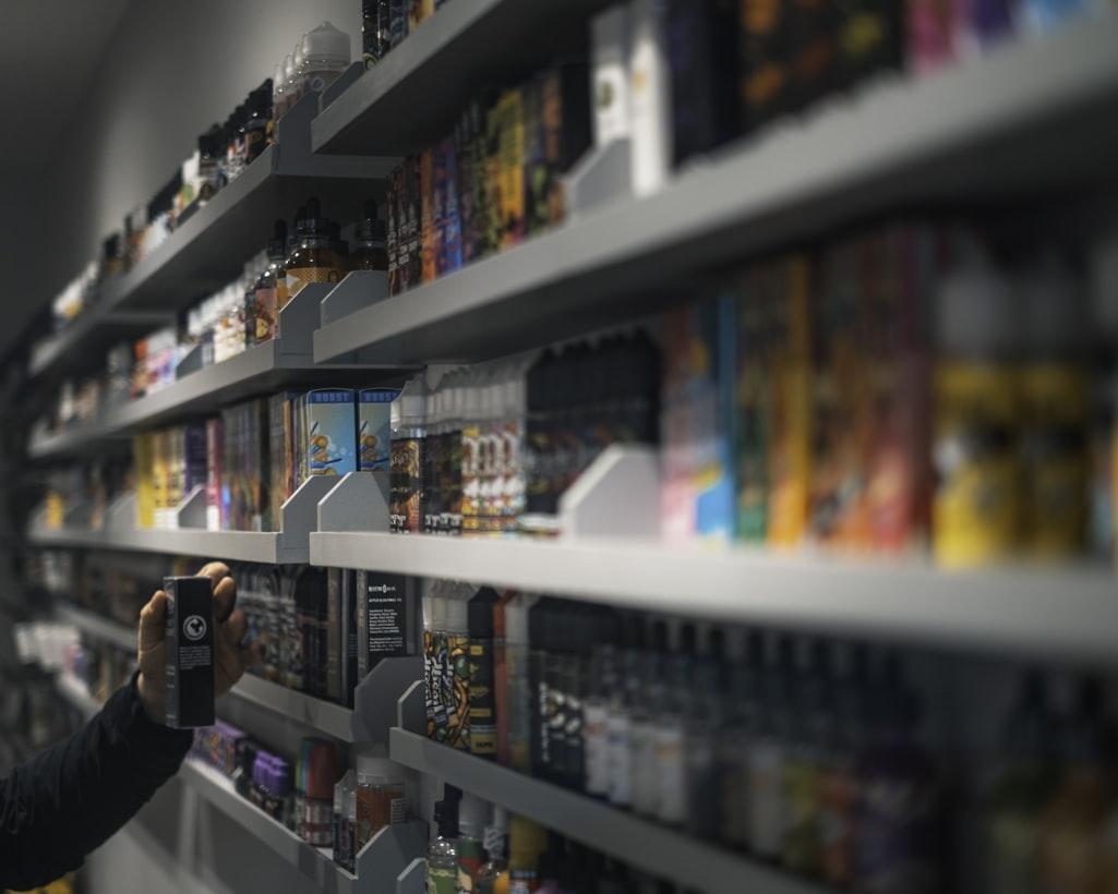 Person standing in front of a store shelf reviewing product packaging